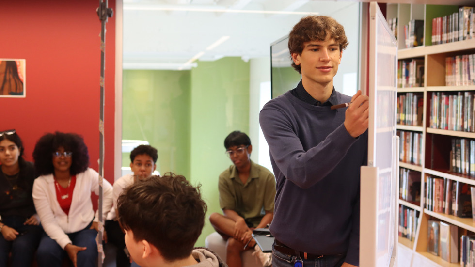 Brown student Justin Dunn writes at a whiteboard at the teen loft in the Providence Public Library. 