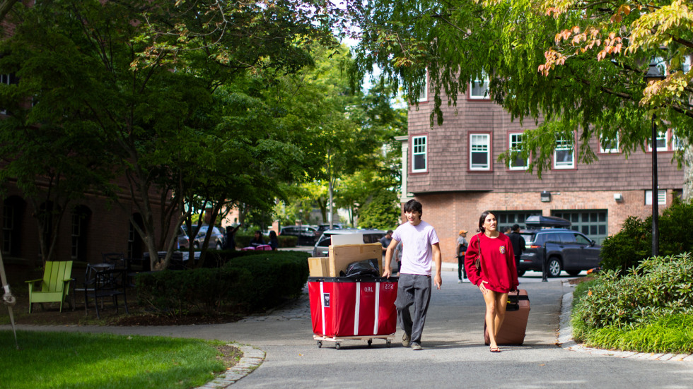 Two people wheel a cart on move-in day