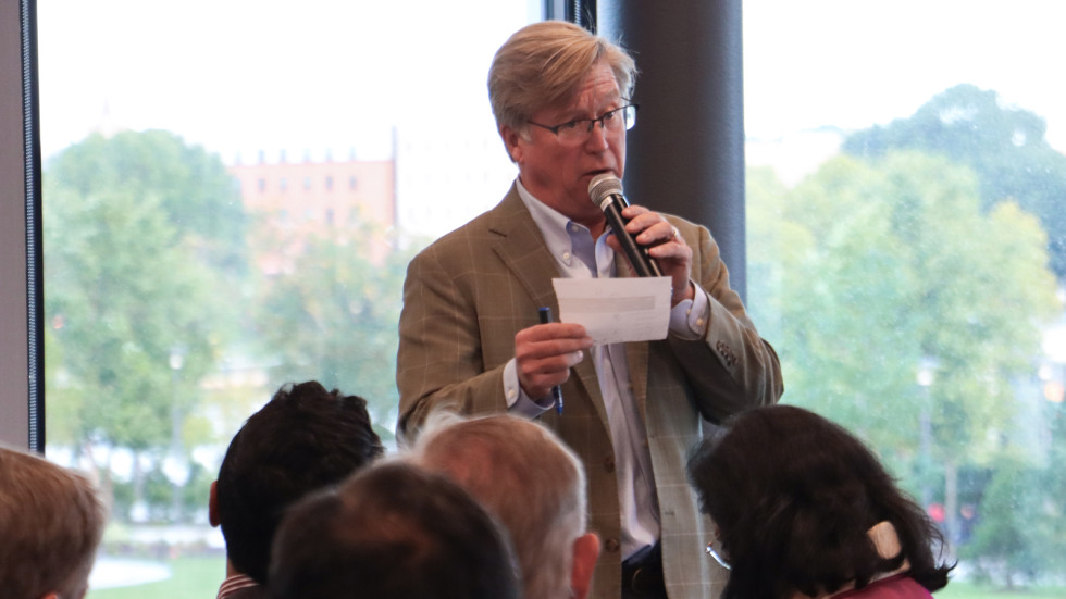 A venture capitalist holds a mic and emcees the event. 