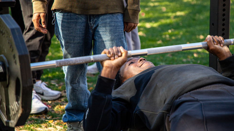 a participant for the bench press for cancer prepares to push weight upward