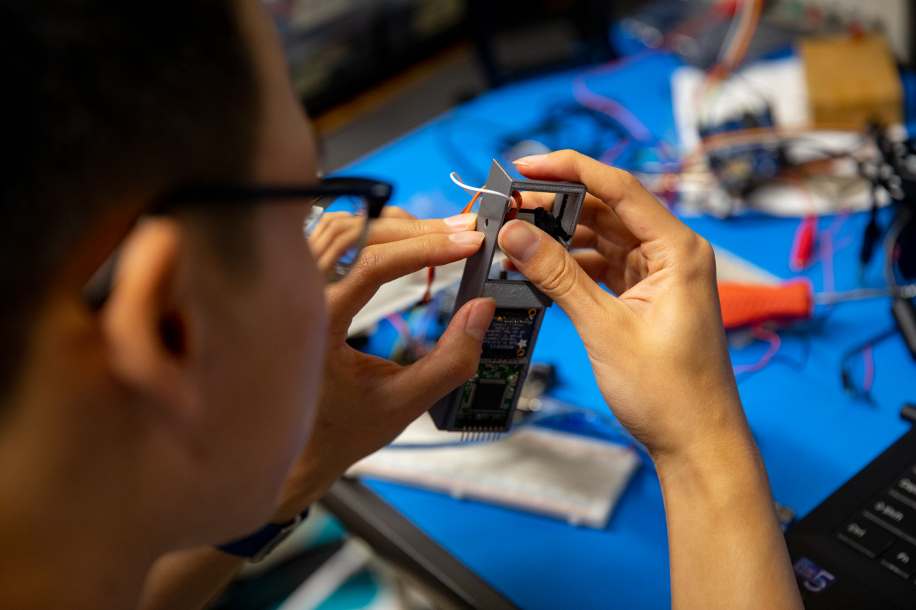 Student works with parts of robotic arm