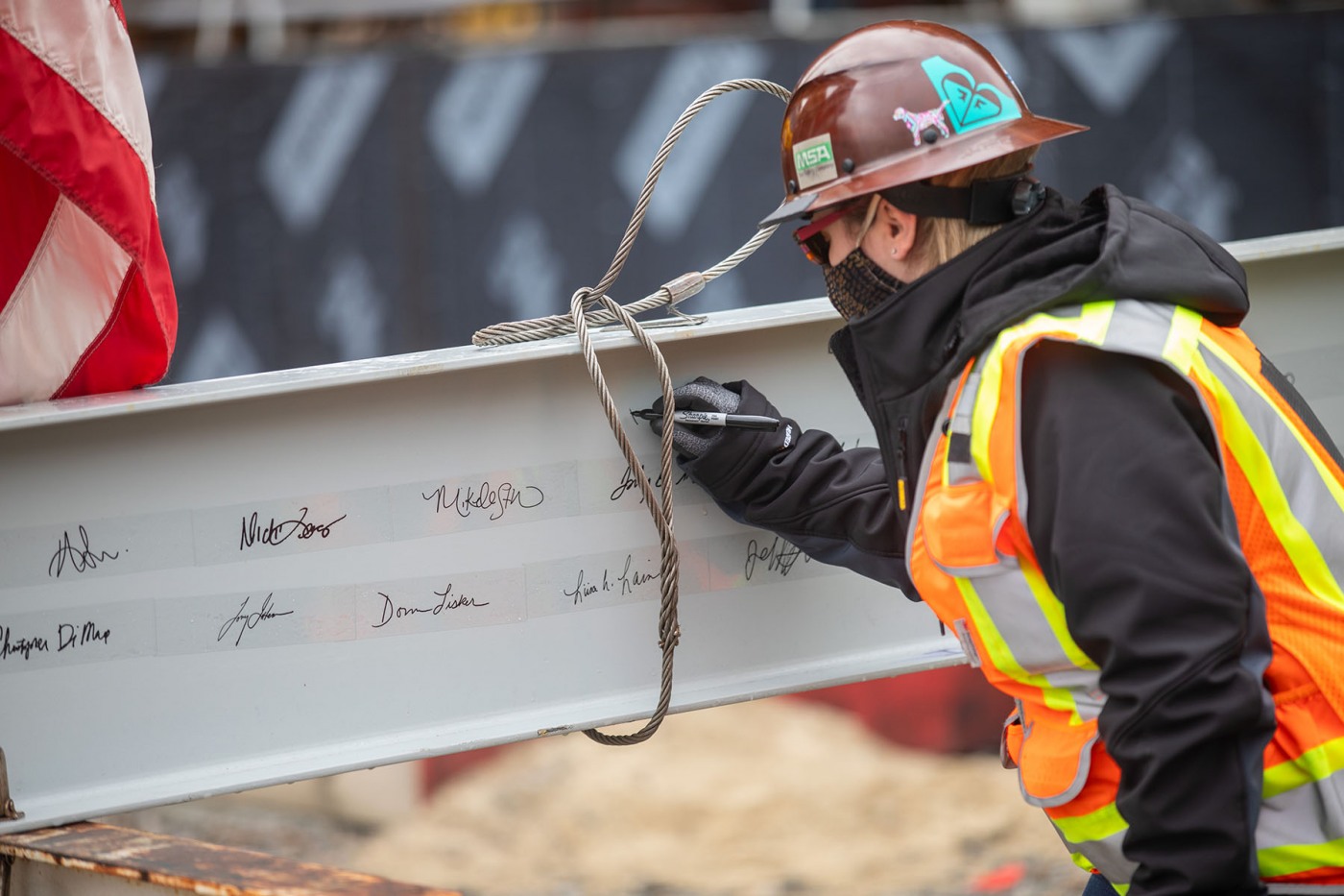 Worker signing final beam.