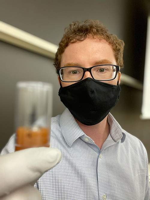 An image of Ralph Milliken holding the asteroid sample