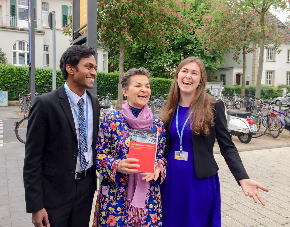 Sujay Natson and Victoria Hoffmeister smiling and posing with Christiana Figueres in Bonn, Germany