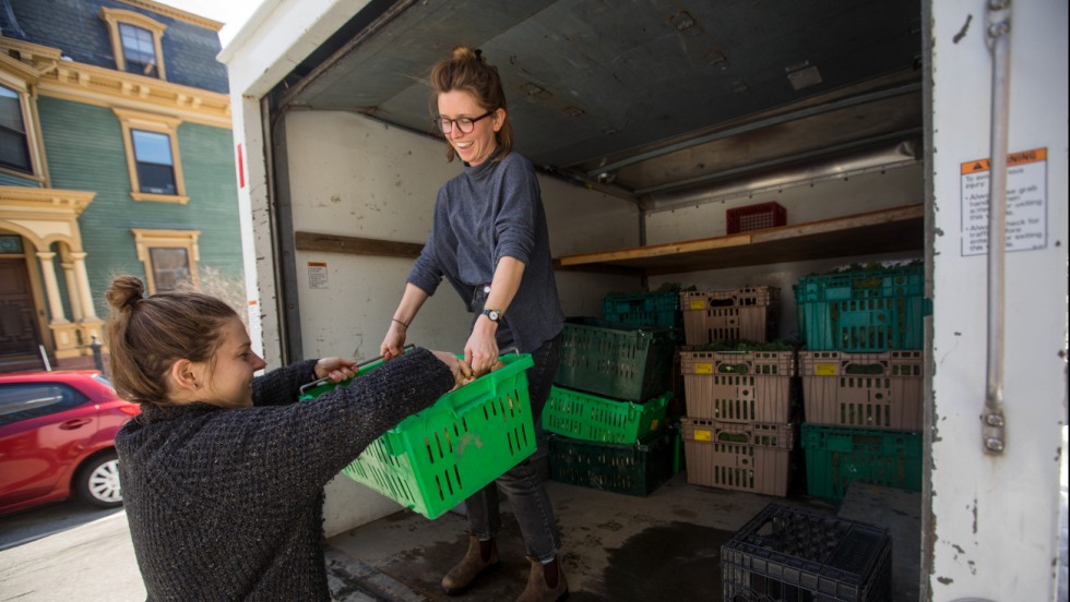Market share students hoisting produce into truck