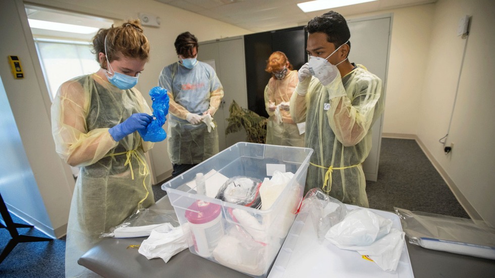 Clinic workers putting on personal protective equipment