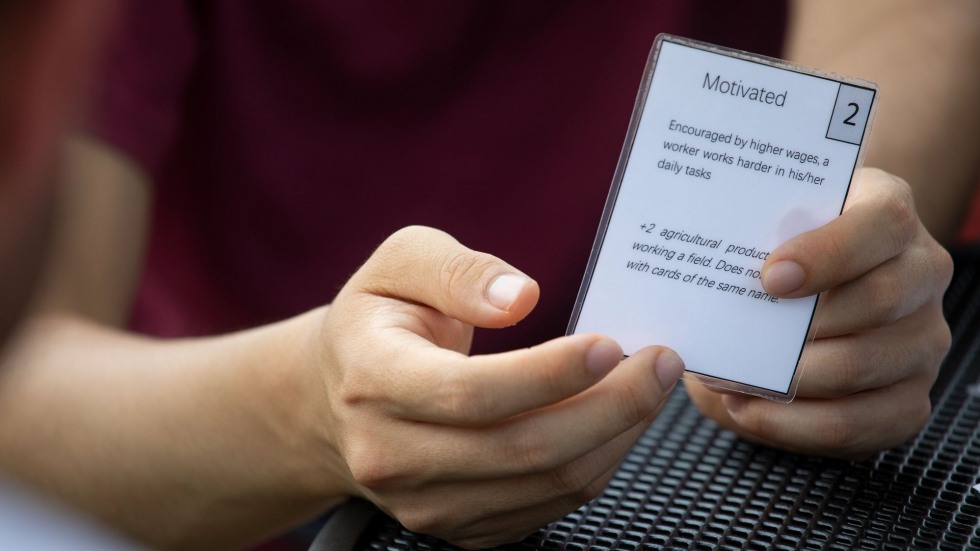 person holding a game card that says "motivated"