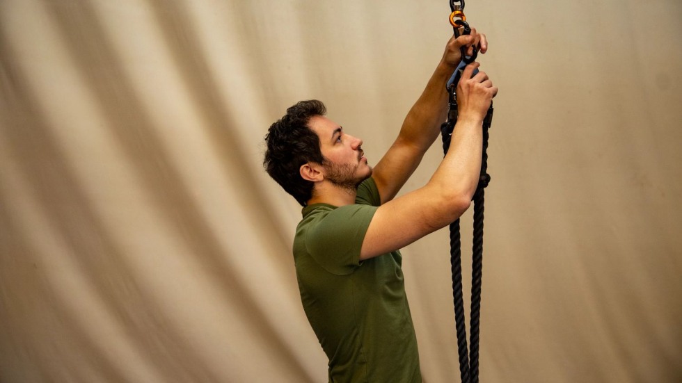 man adjusting a rope on a large carabiner