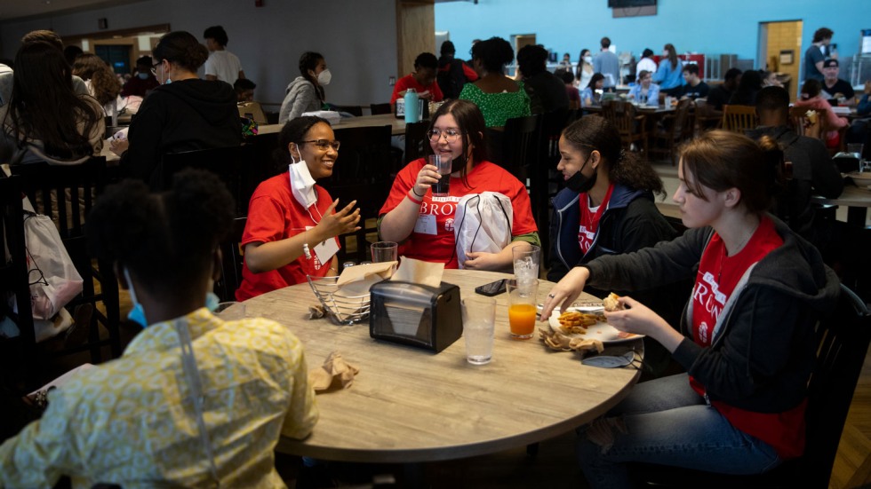 four students talking and eating around a table