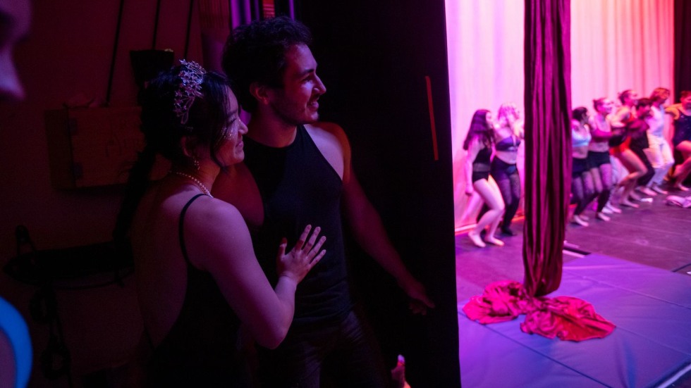 two students embracing backstage 