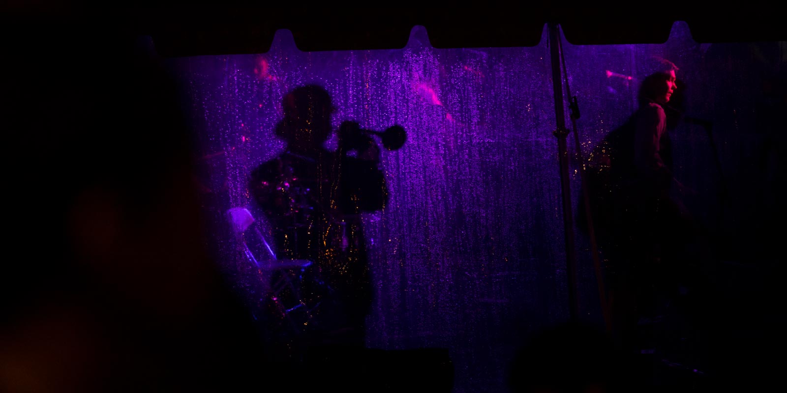 A horn player from the band Lawrence casts a shadow onto the tent wall of the Campus Dance stage on Simmons Quad.