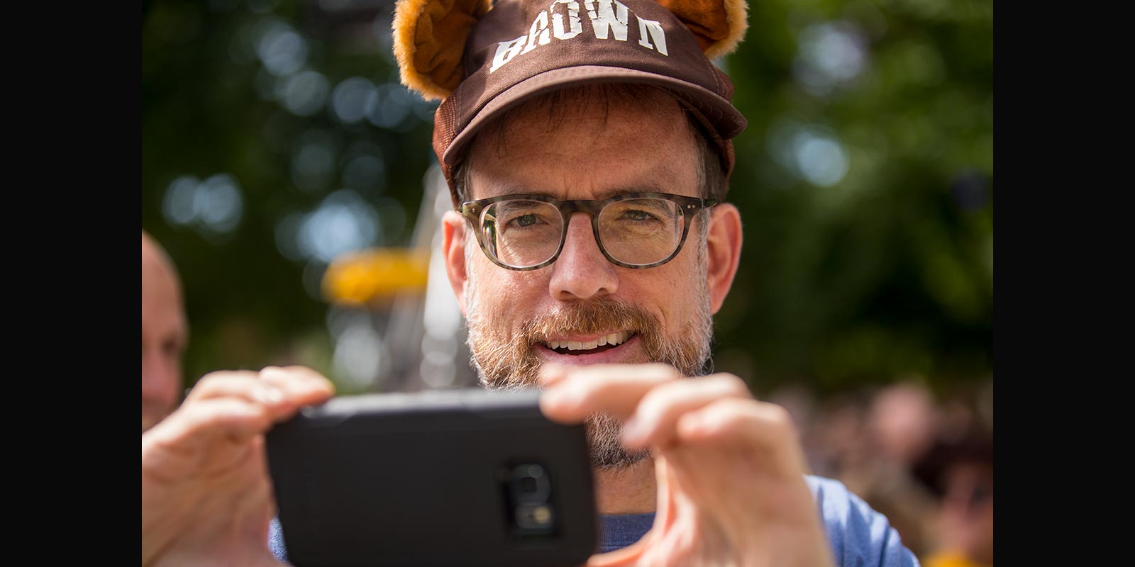 With "ears" up and camera scanning, Class of 1987 graduate Rick Perera headed down College Hill amid the alumni procession.