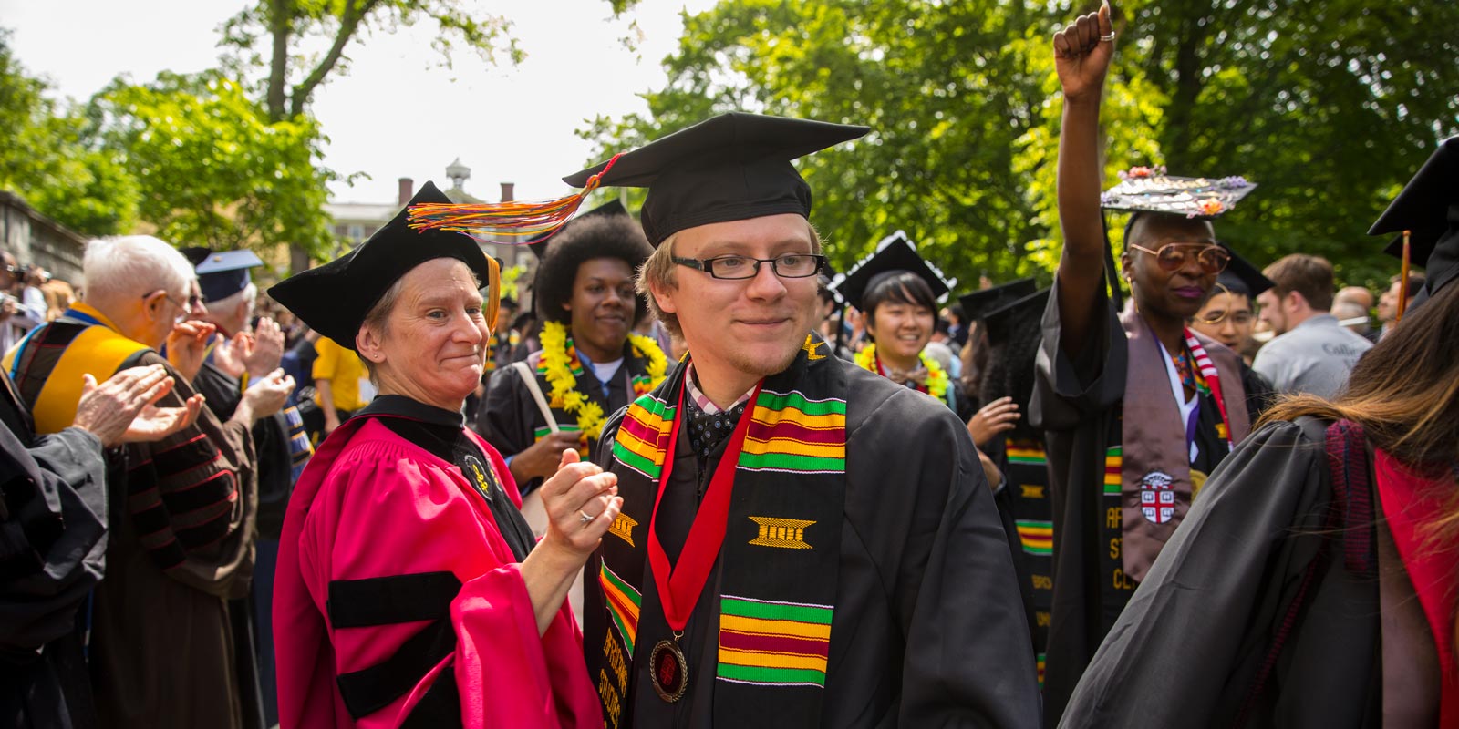 Donning a sash and medal, Nico Sedivy (center), who earned a bachelor of arts degree, processed down College Street.