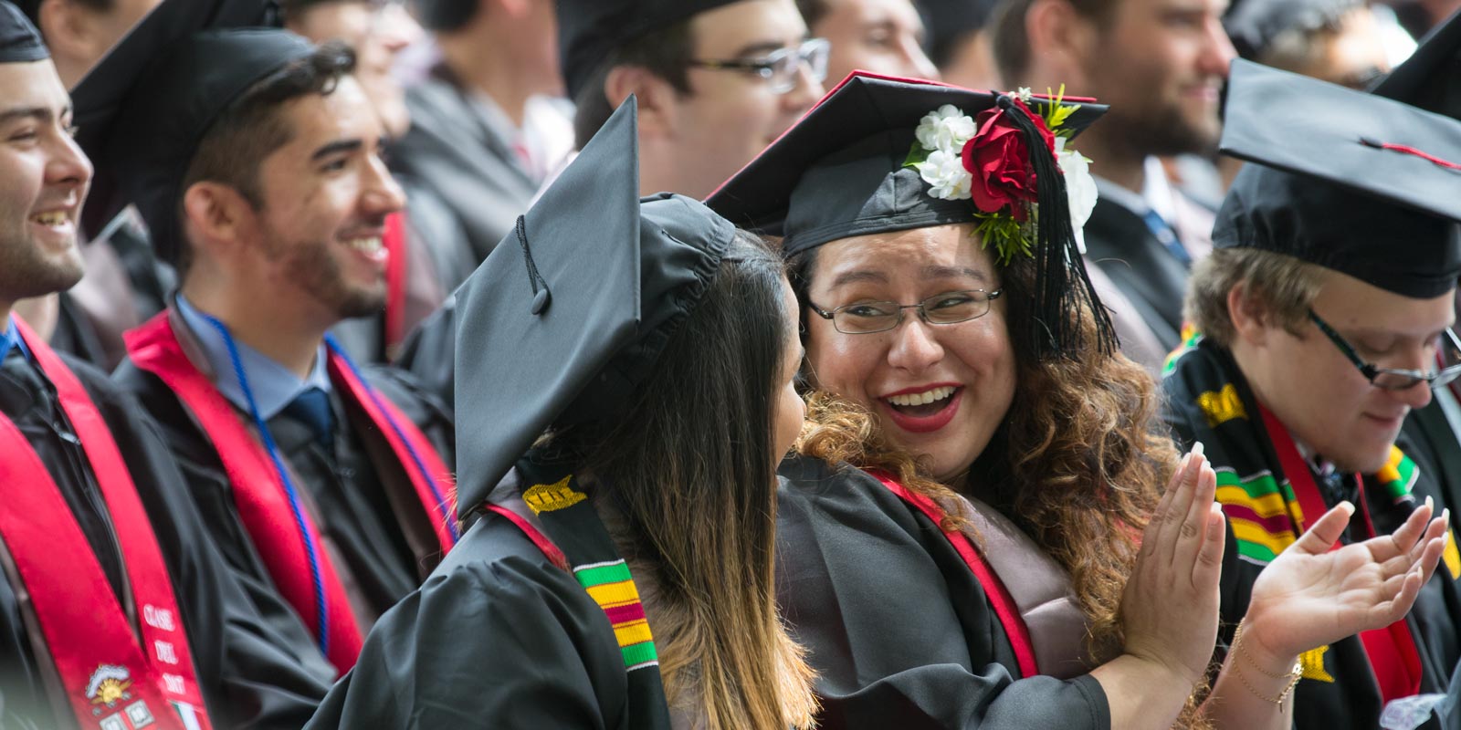 Noemi Chavez Velazquez laughed with a fellow graduate during the University Ceremony.