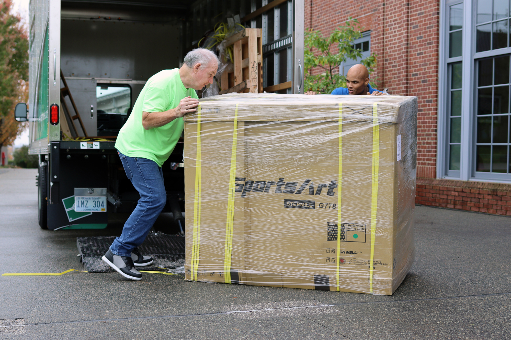 Workers move an equipment box into the gym
