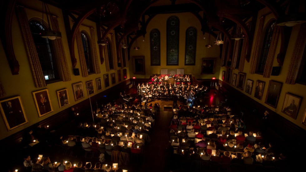 Aerial view of audience holding lit candles in the dark