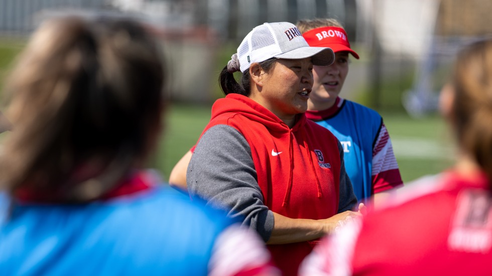 Women's rugby coach Rosalind Chou stands on the sidelines