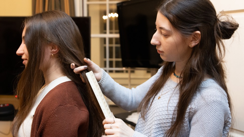 student measures the length of another's hair
